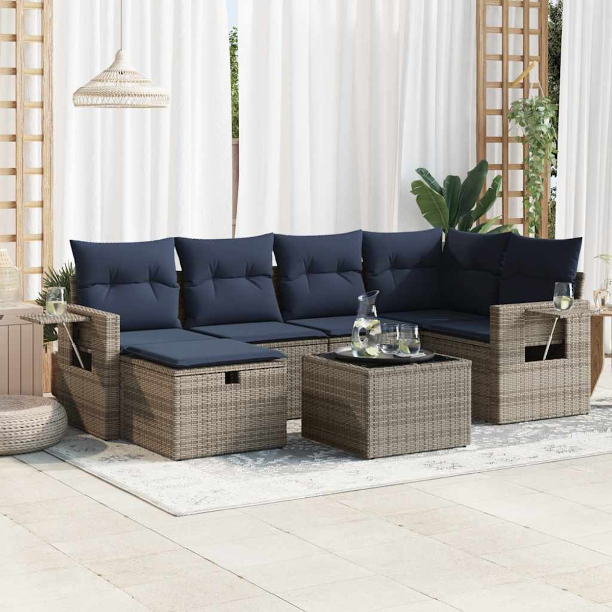 Outdoor-Ecksofa mit marineblauen Kissen, Couchtisch und Teppich vor transparenten Vorhängen.