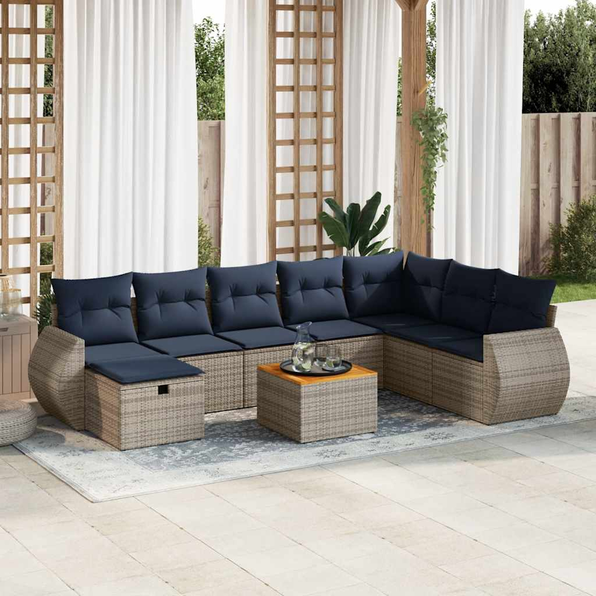 L-förmiges Outdoor-Sofaset mit Tisch und blauen Kissen. Weiße Vorhänge im Hintergrund.