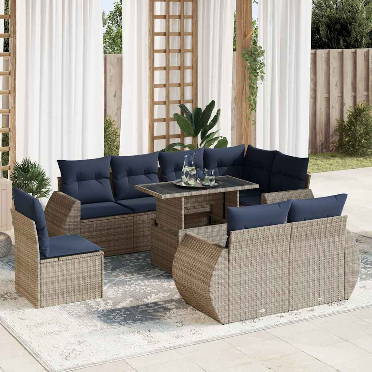 Outdoor-Möbelset mit marineblauen Kissen. Enthält ein Sofa, zwei Stühle und einen Tisch mit Teppich.