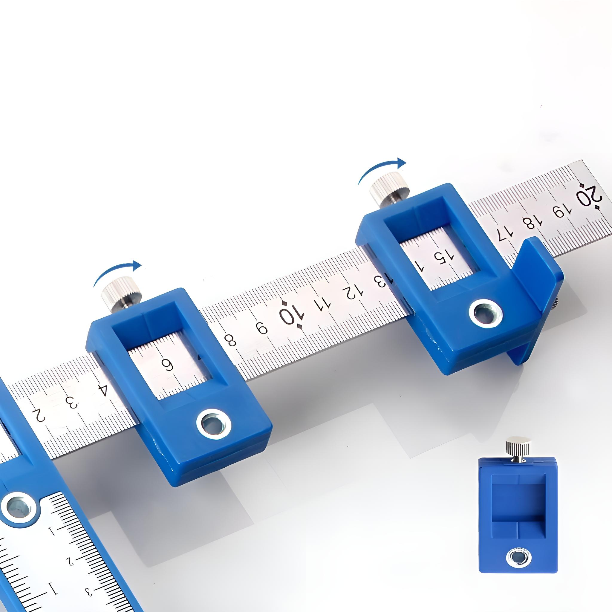 Blaue Messlehren sind auf einem Metalllineal. Die Vorrichtungen haben verstellbare Knöpfe und dienen zum Messen.