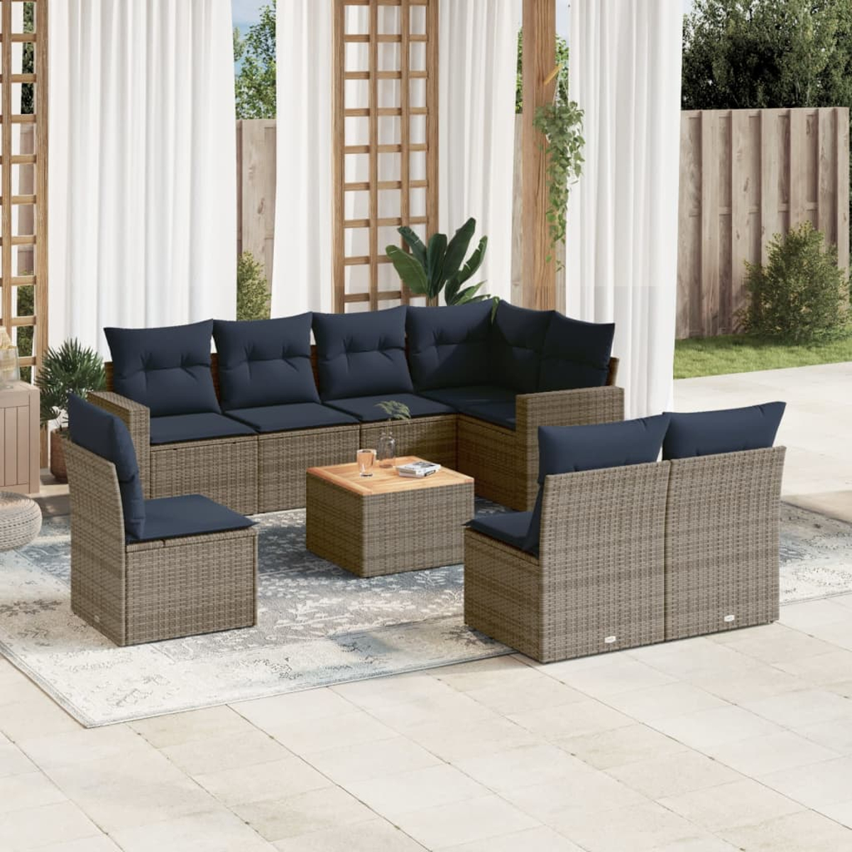 Outdoor-Ecksofa mit marineblauen Kissen, einem Couchtisch, auf einer Terrasse mit weißen Vorhängen.