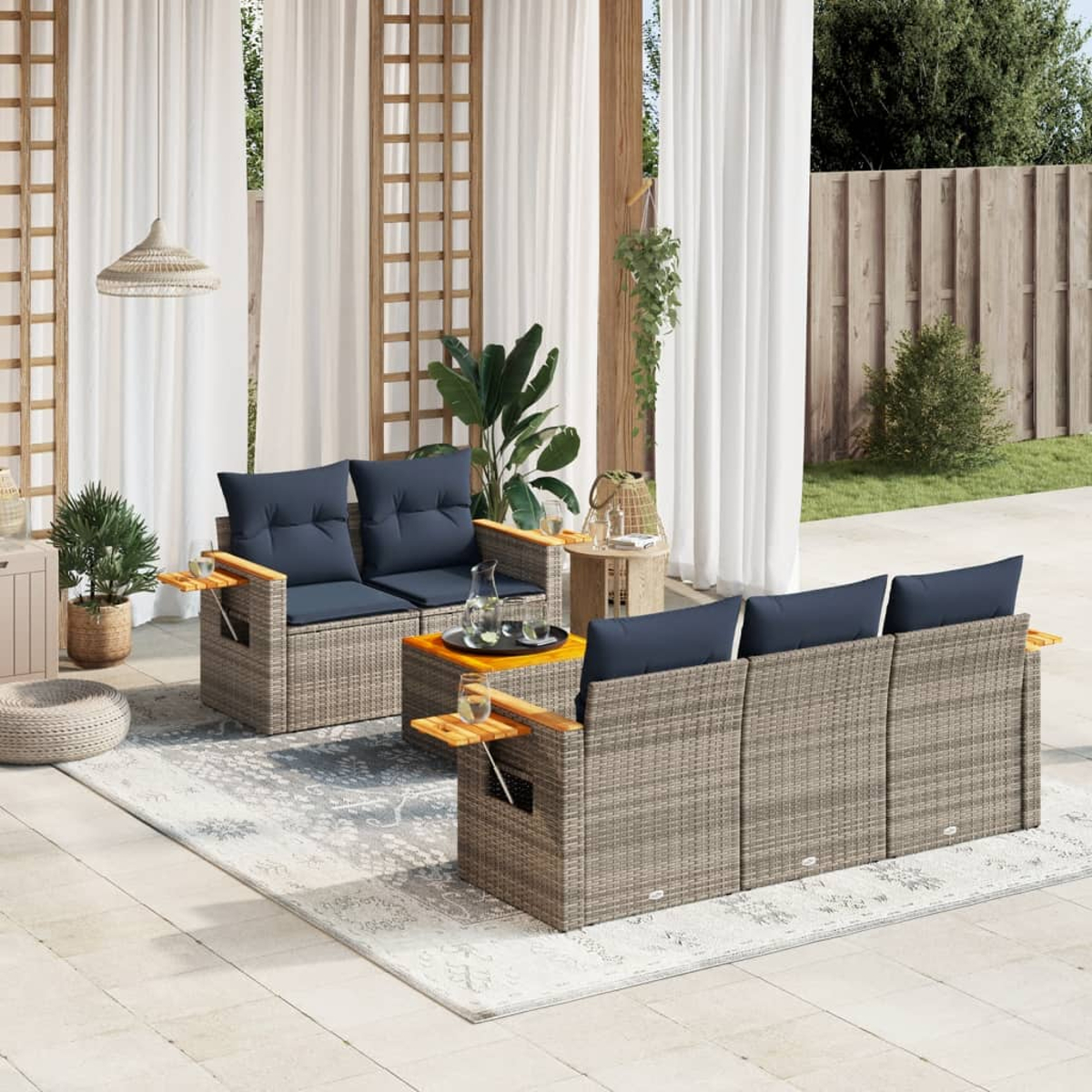 Outdoor-Sitzgruppe mit blauen Kissen, einem Couchtisch und einem gemusterten Teppich.