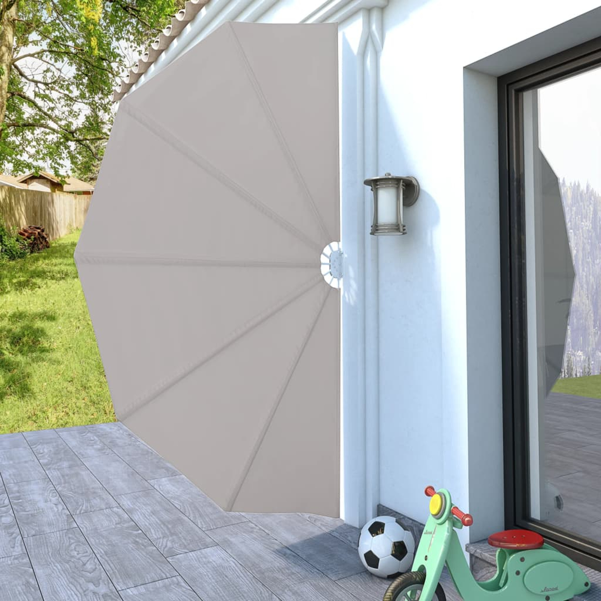 Ein beigefarbener Sonnenschirm an einer weißen Wand, mit Roller und Ball im Vordergrund.