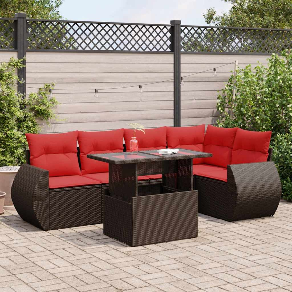 Dunkelbraunes Korbsessel-Sofa mit roten Kissen und Couchtisch, Szene im Freien.