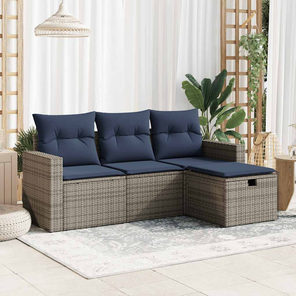 Ein beiges Ecksofa mit marineblauen Kissen auf einer Außenterrasse mit Teppichen und Dekoration.