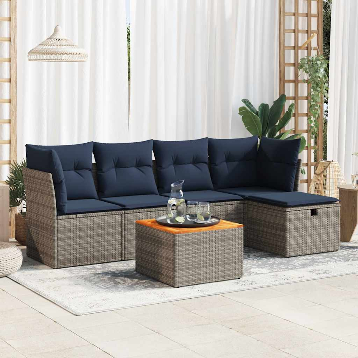 Ein beiges Ecksofa mit marineblauen Kissen, Couchtisch und Dekoration auf einer Terrasse.