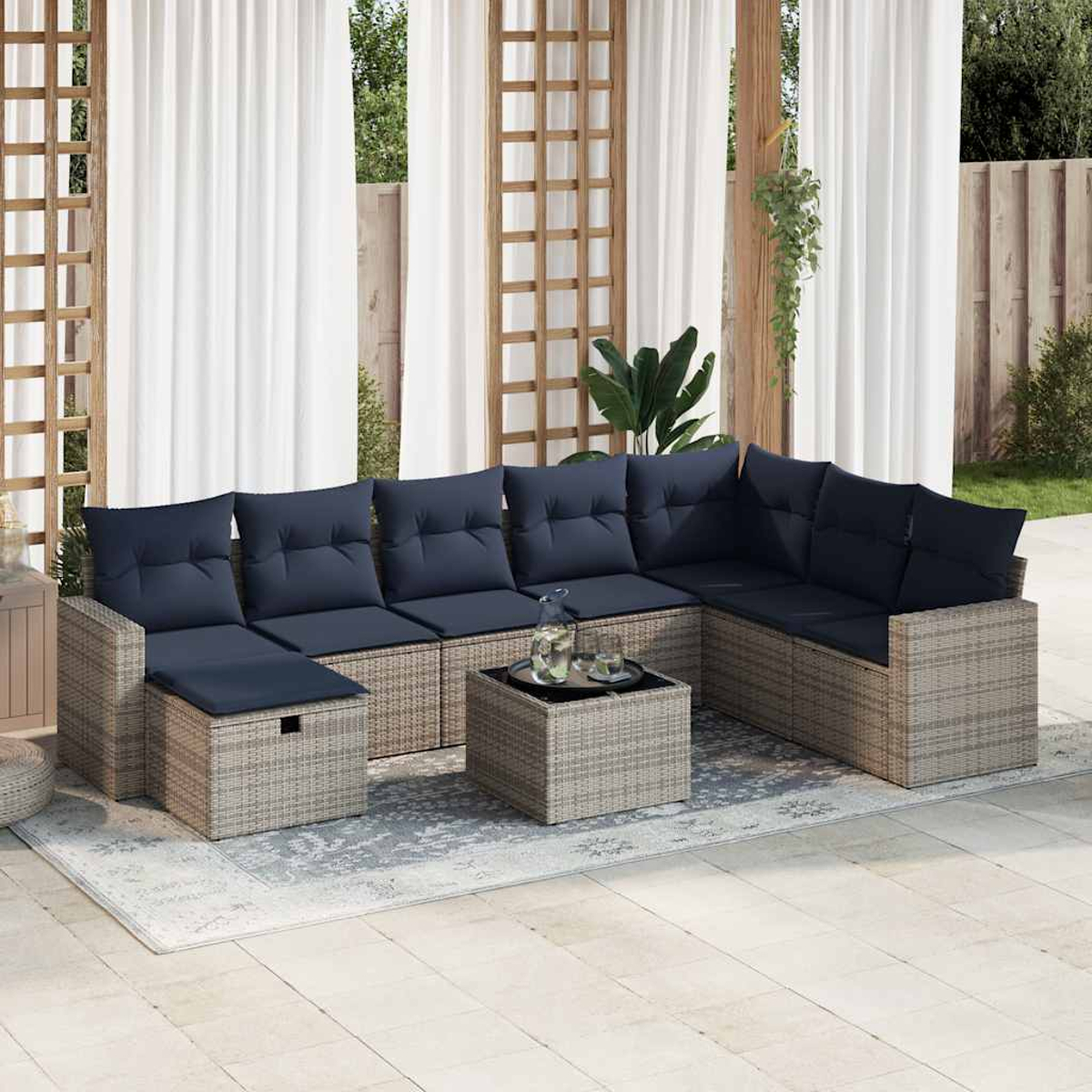 Outdoor-Ecksofa mit marineblauen Kissen und Holztisch. Weiße Vorhänge.