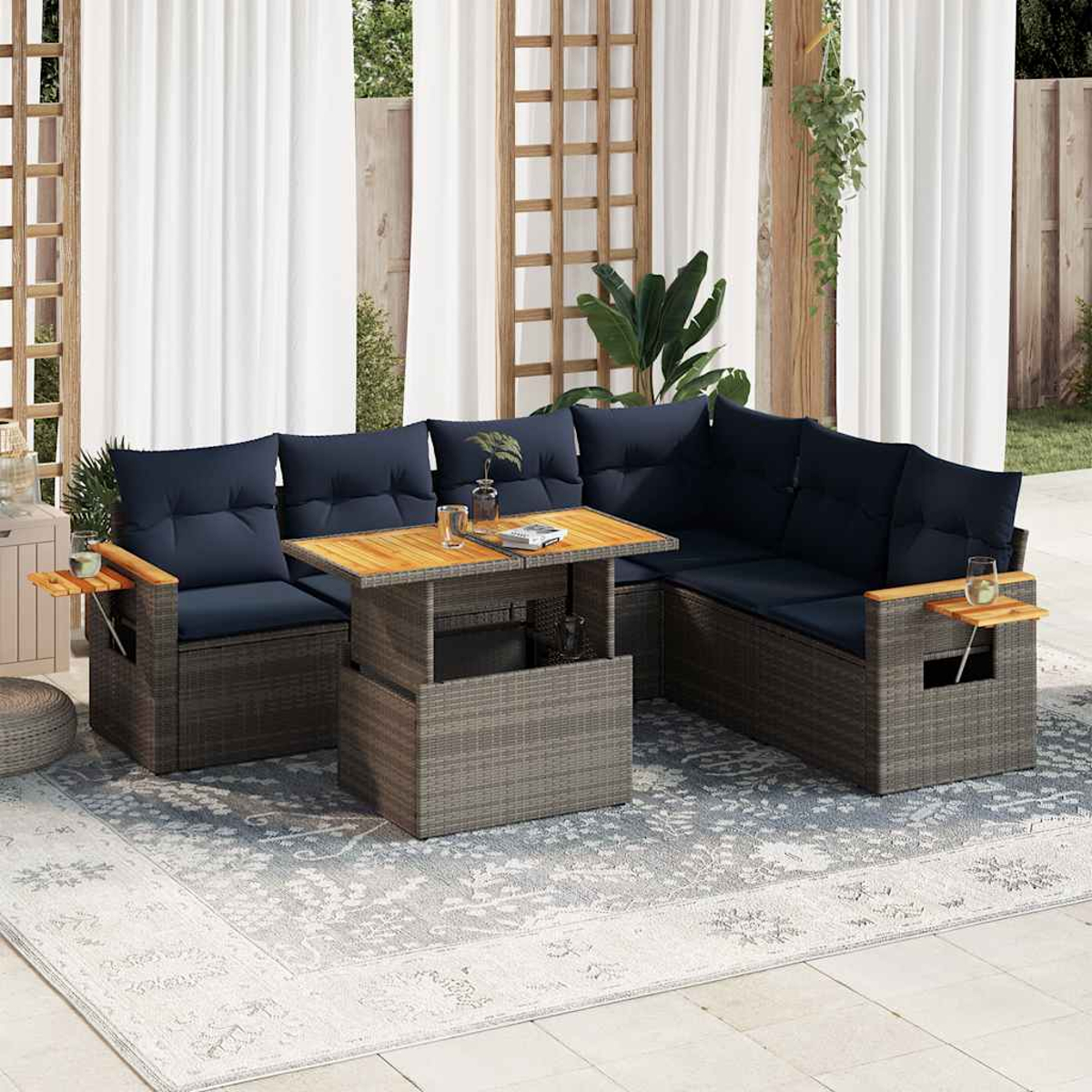 Graues Rattan-Outdoor-Ecksofa mit blauen Kissen und einem Holztisch auf einem Teppich.