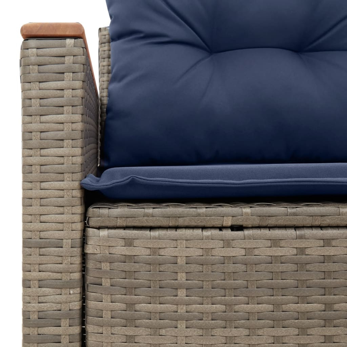 Nahaufnahme einer grauen Rattan-Sofa-Armlehne mit einem blauen Kissen.