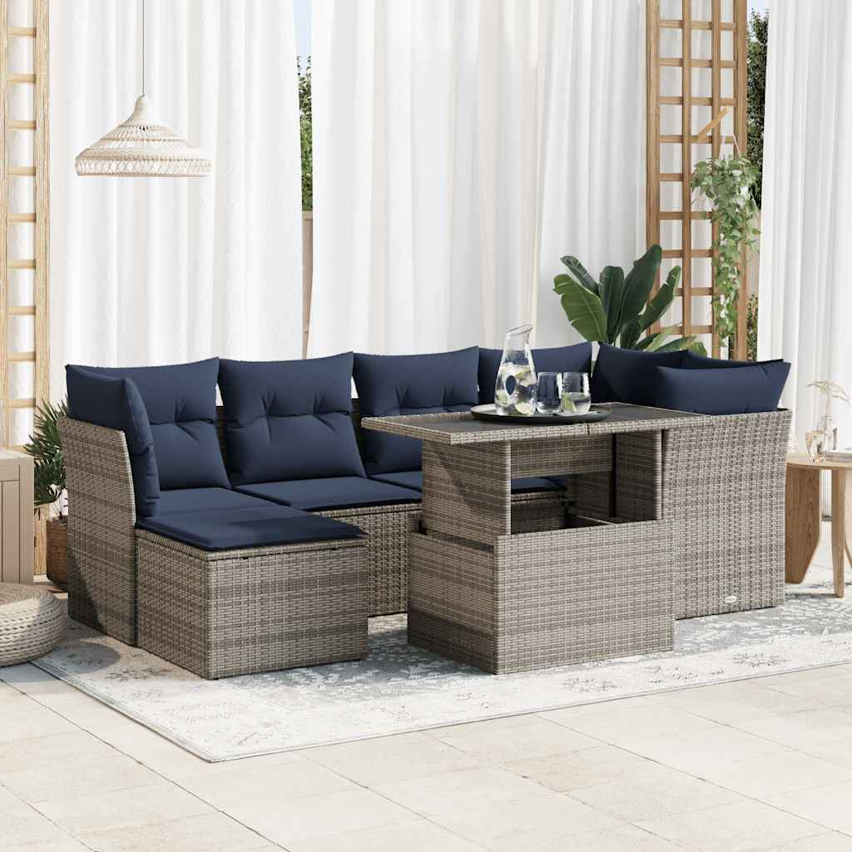 Outdoor-Wicker-Sofagarnitur mit blauen Kissen, Tisch und Zubehör auf einer Terrasse.