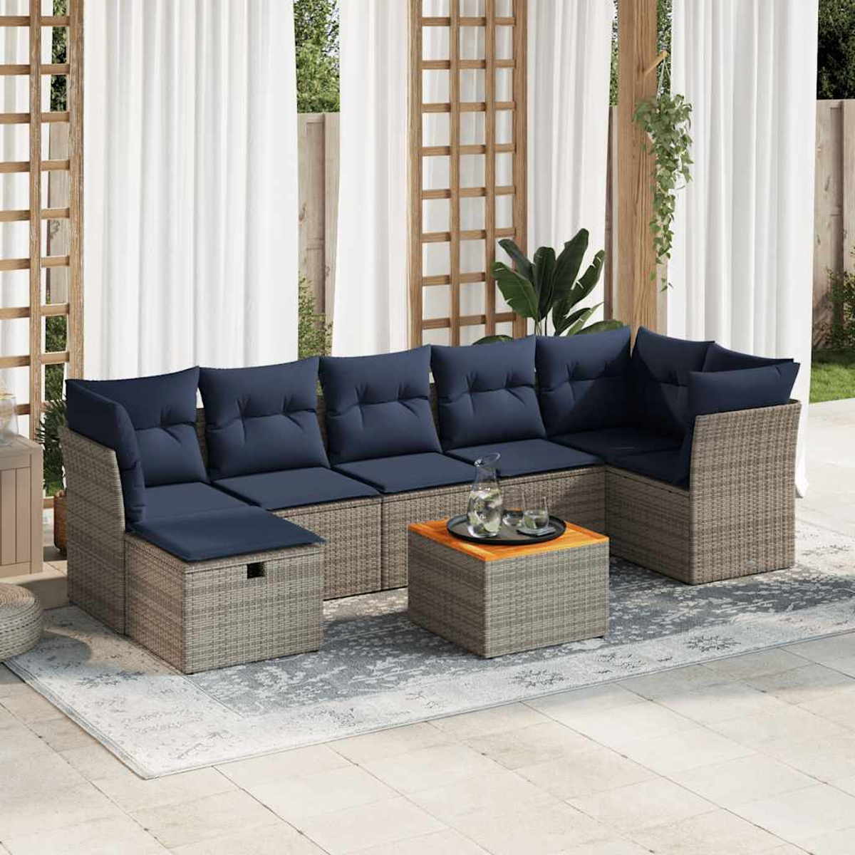 Sofá seccional de exterior con cojines azules y una mesa pequeña, en un jardín.