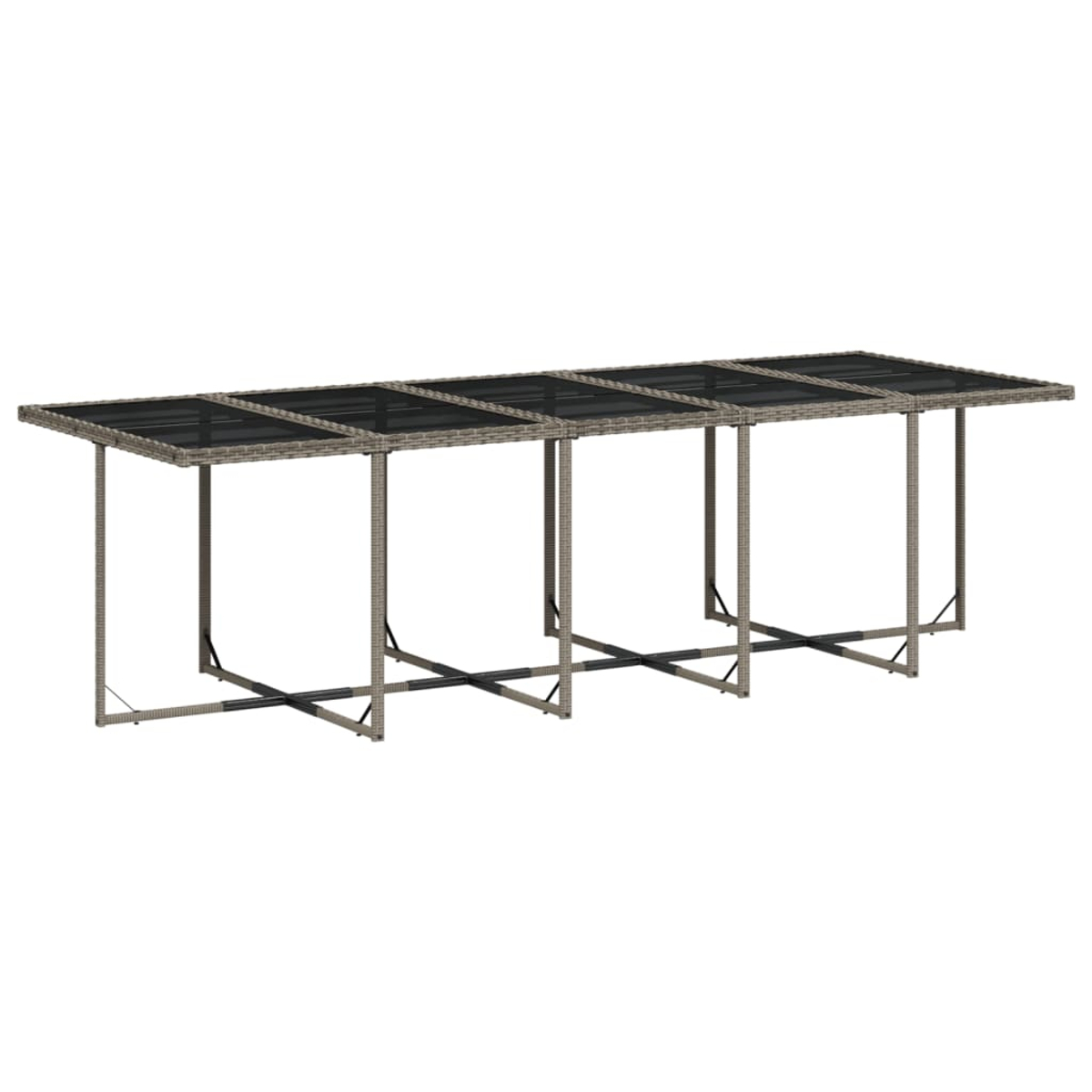 Langer Außentisch mit Glasplatte und Korbgeflechtrahmen. Der Tisch ist leer und hat keine Stühle.