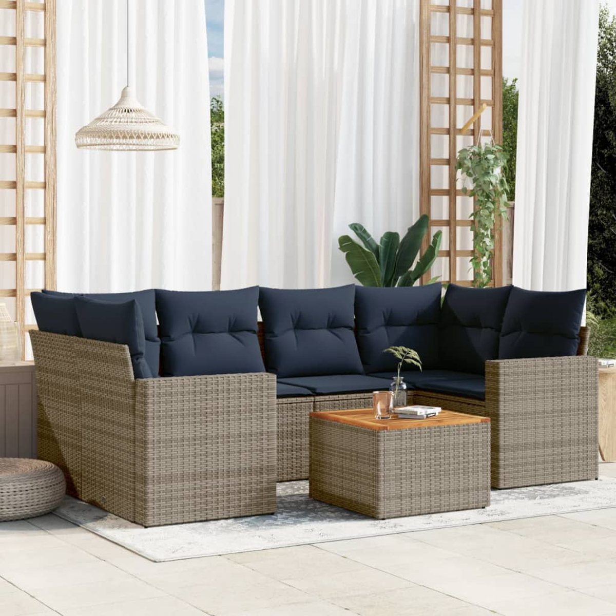 Outdoor-Rattansofa-Set mit blauen Kissen und einem Holztisch. Die Szene ist auf einer Terrasse mit Vorhängen.