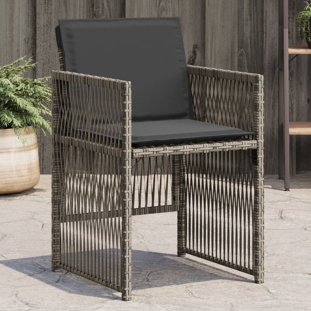 Grauer Korbstuhl mit schwarzem Kissen, auf einer Terrasse mit Topfpflanze und Holzzaun im Hintergrund.