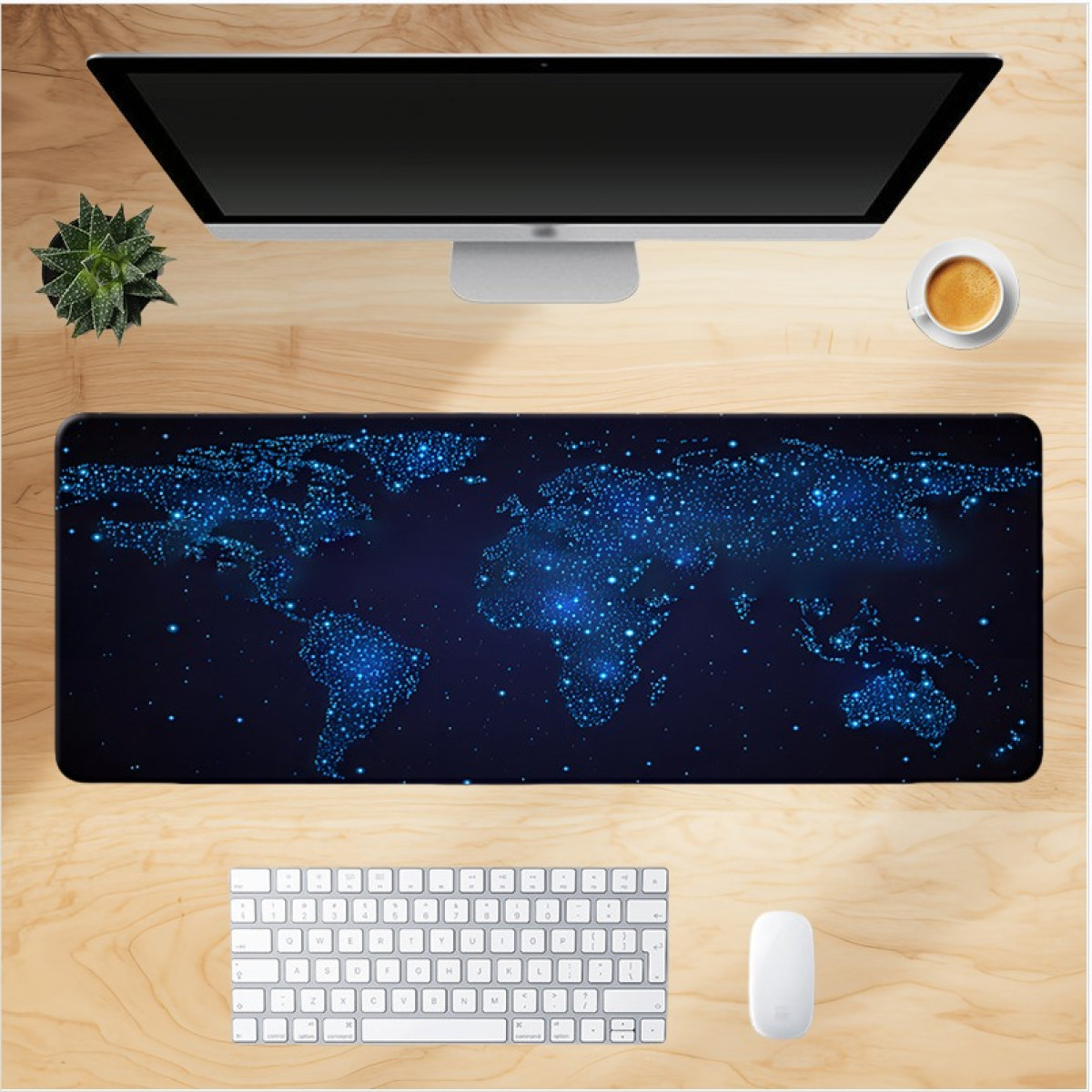 Una scrivania con tappetino per mouse con mappa del mondo, monitor, tastiera, mouse e una tazza di caffè sopra.