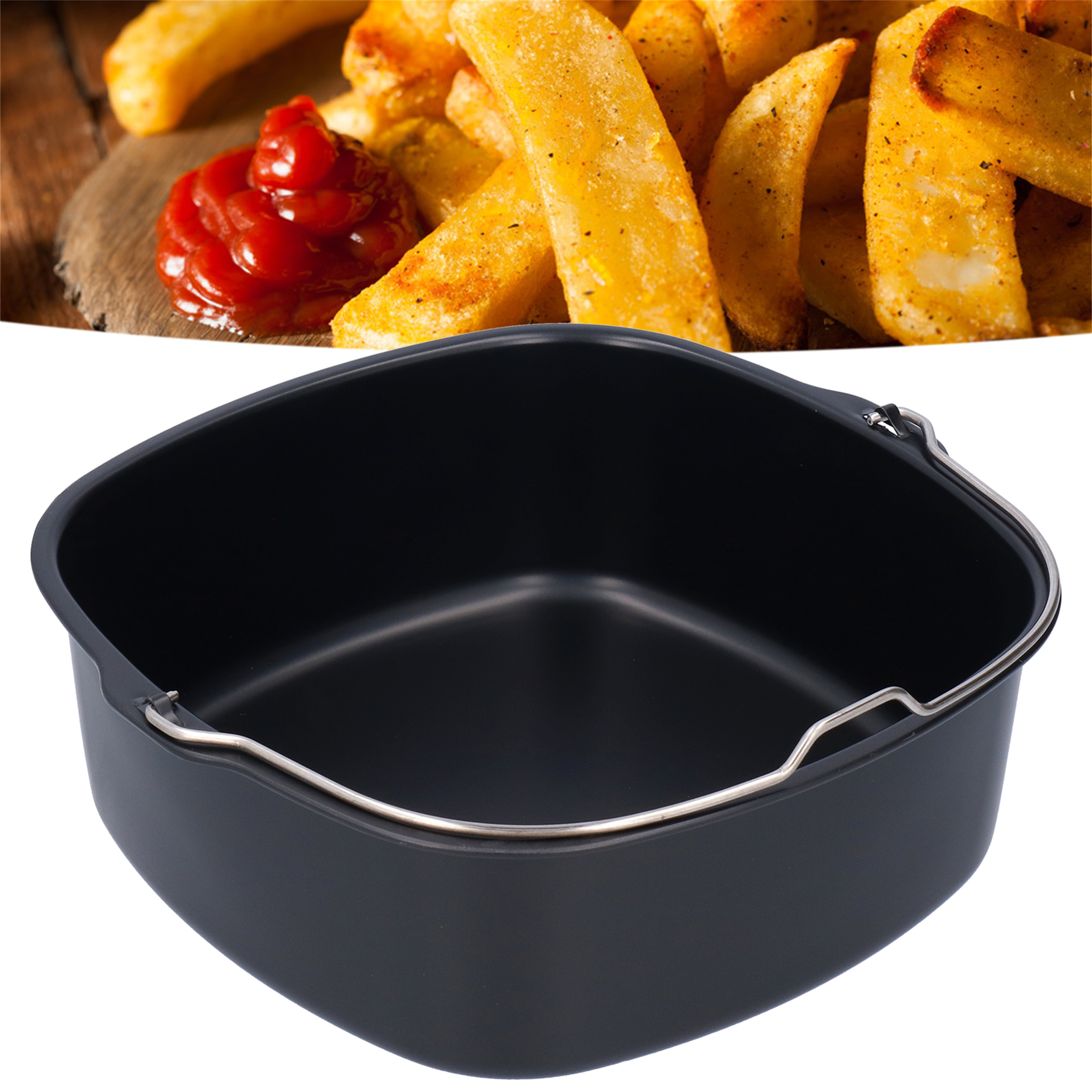 Ein schwarzer Airfryer-Korb mit Pommes und Ketchup, vor weißem Hintergrund.