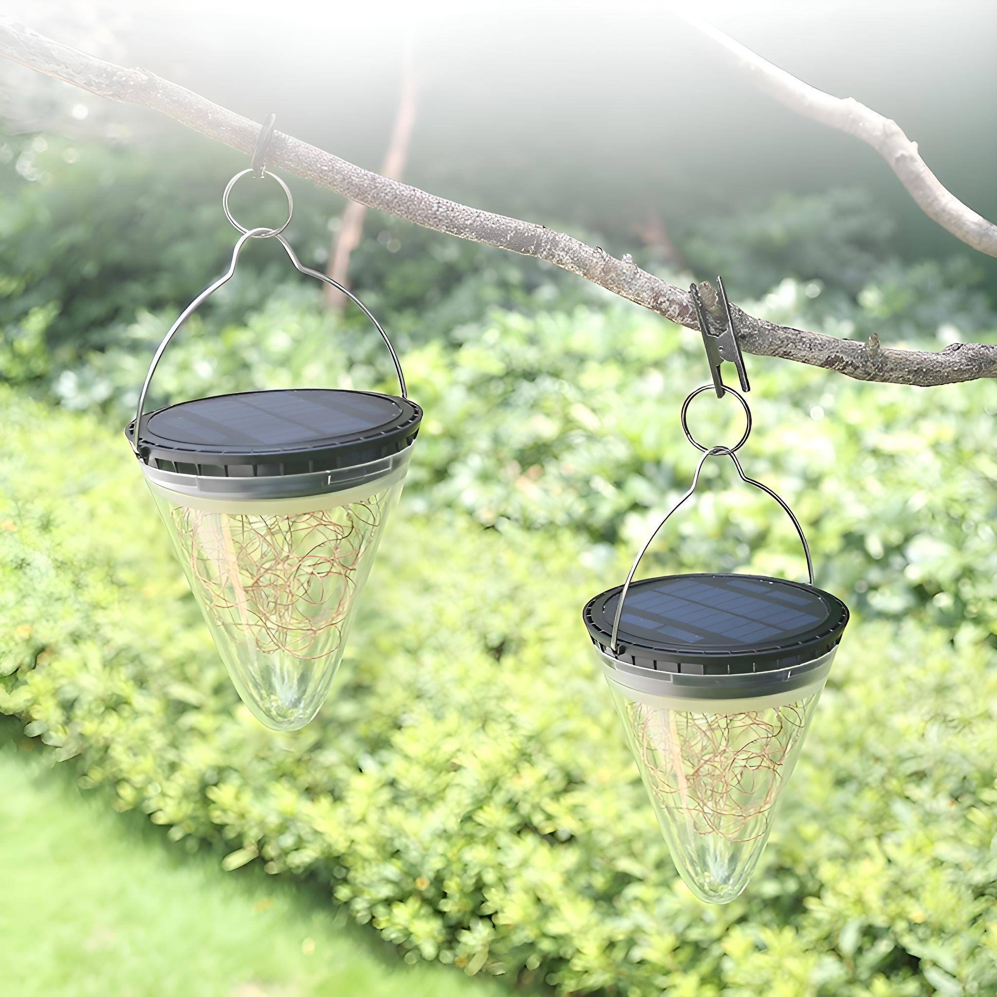 Zwei kegelförmige Solarlichter mit Lichterketten, die an einem Ast hängen.