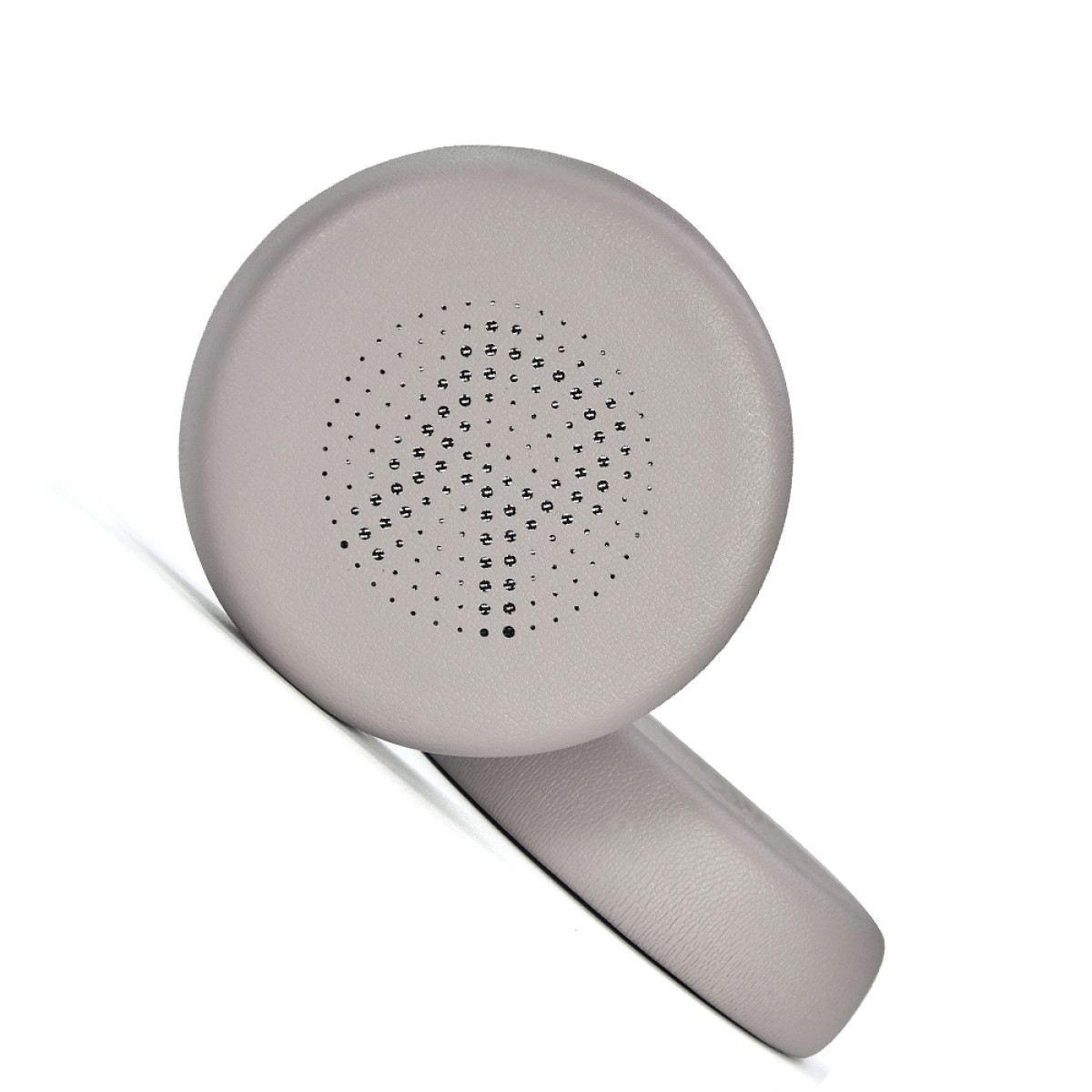 Un cuscinetto auricolare grigio chiaro. Ha un interno in rete e un piccolo foro per il suono. Il cuscinetto è rotondo.