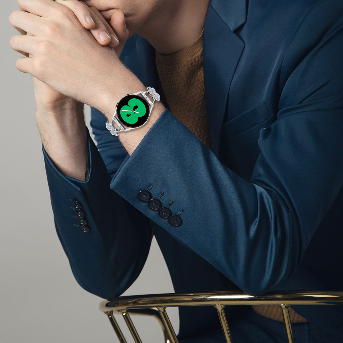 Ein Mann trägt einen blauen Blazer und eine Uhr mit grünem Bildschirm am Handgelenk.