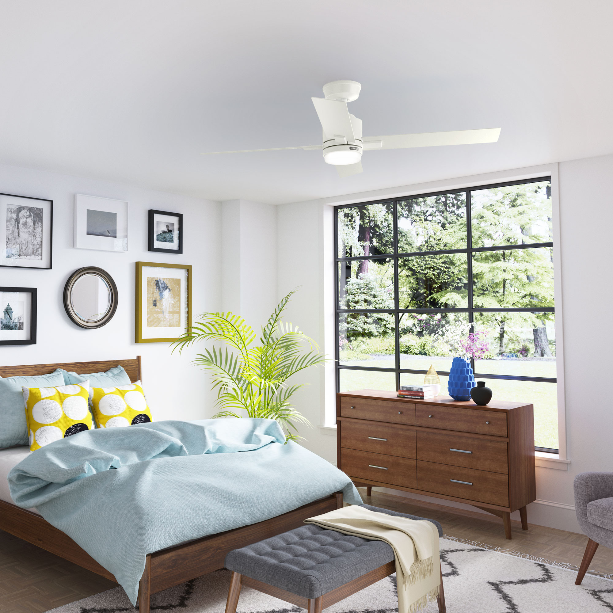 Schlafzimmer mit Bett, großem Fenster, Kunstwerken und Deckenventilator.