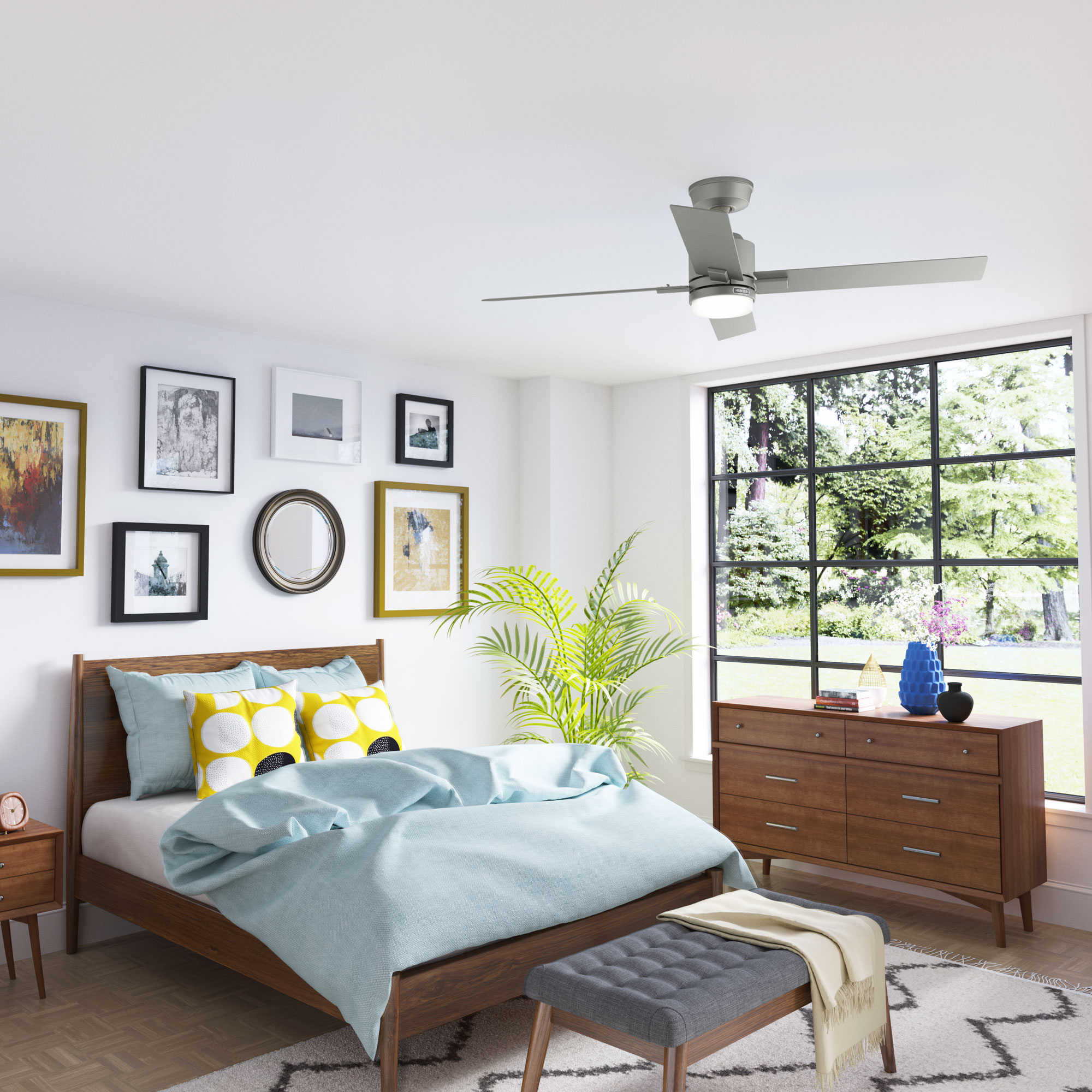Ein Schlafzimmer mit Bett, Kunstwerken und Deckenventilator. Ein großes Fenster und eine Kommode sind ebenfalls vorhanden.