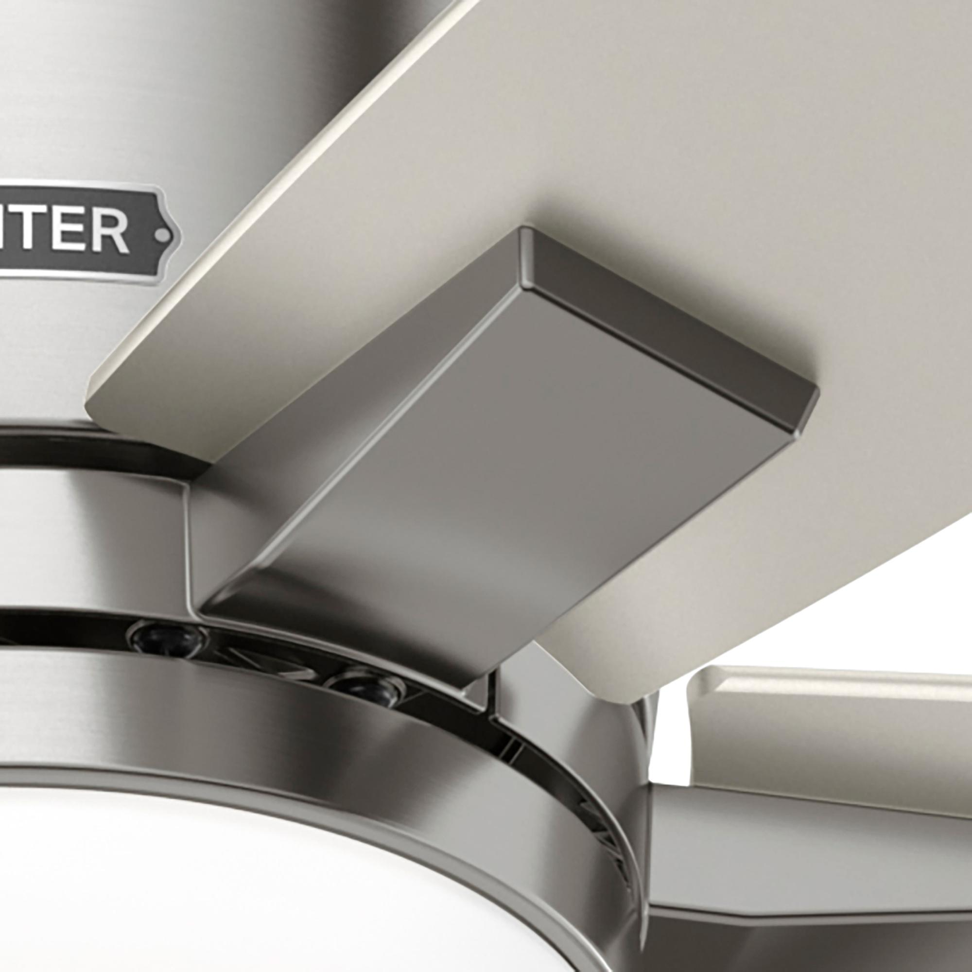 Nahaufnahme eines Deckenventilators, zeigt einen Flügel und seine Befestigung am Motorgehäuse in metallischen Tönen.