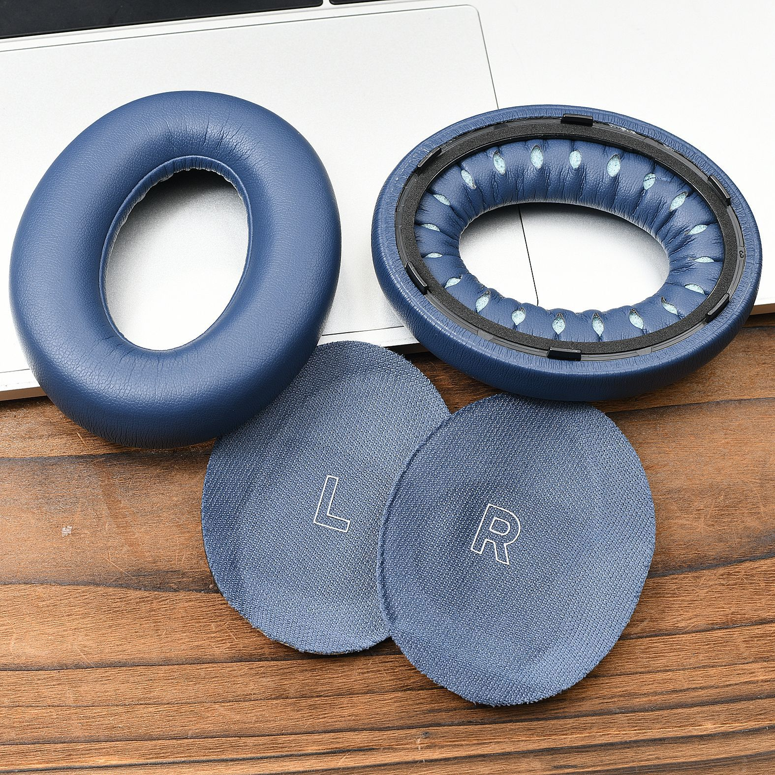 Zwei blaue Ohrpolster, ein inneres blaues Kissen und zwei kleinere Stoffkreise mit 'L' und 'R'.