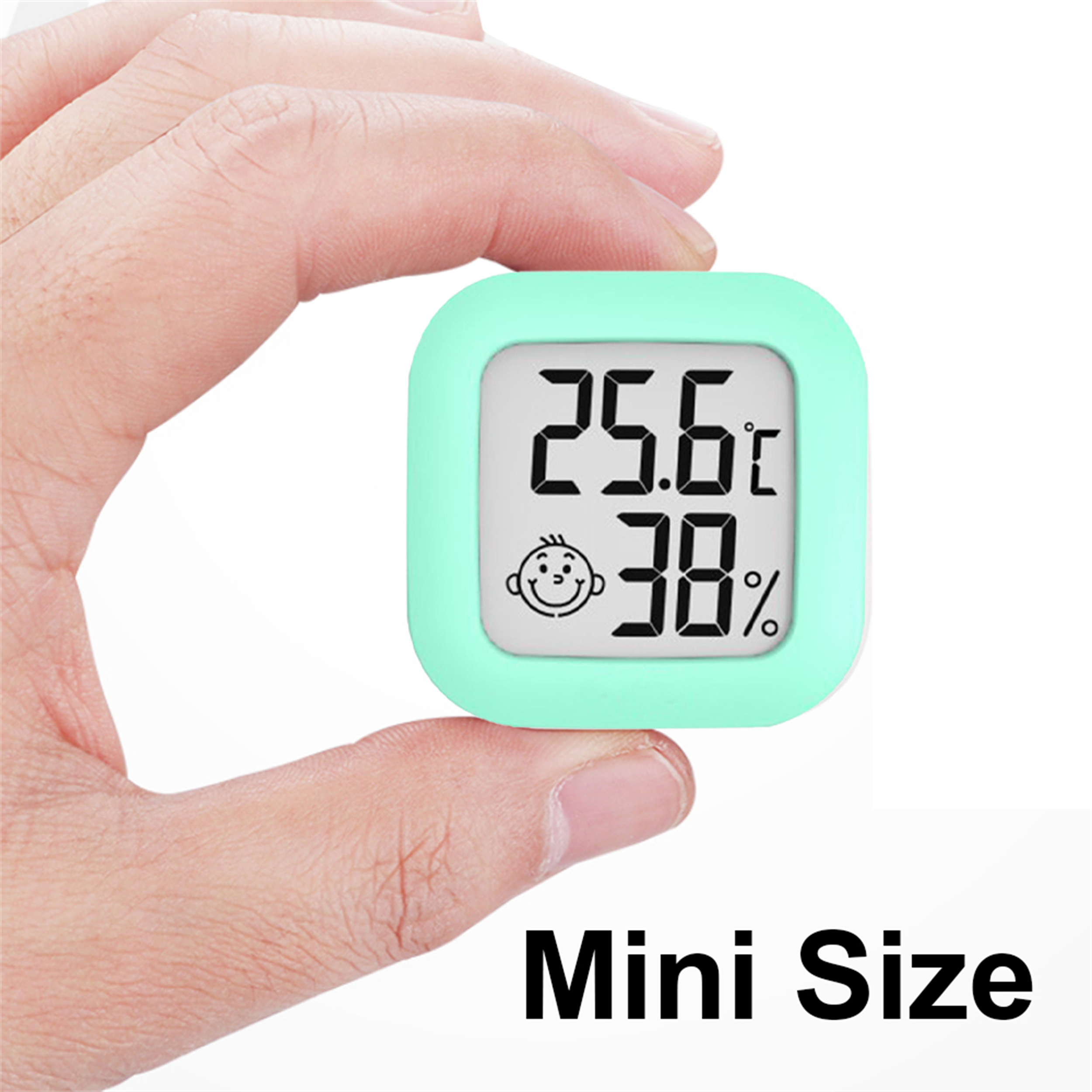 Ein kleiner, mintgrüner quadratischer Digitalthermometer mit einem Smiley-Gesicht. Hand hält das Gerät.
