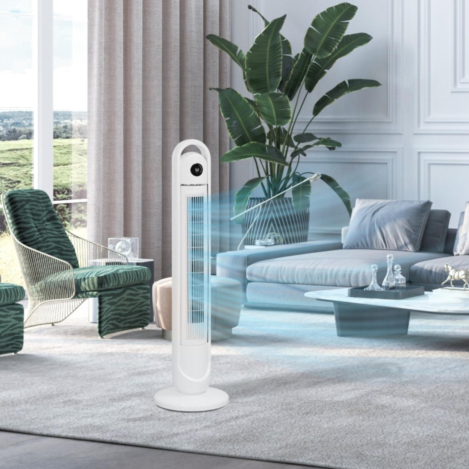 Weißer Turmventilator in einem Wohnzimmer. Blauer Luftstrom ist sichtbar, mit einem grünen Stuhl und Sofa im Hintergrund.