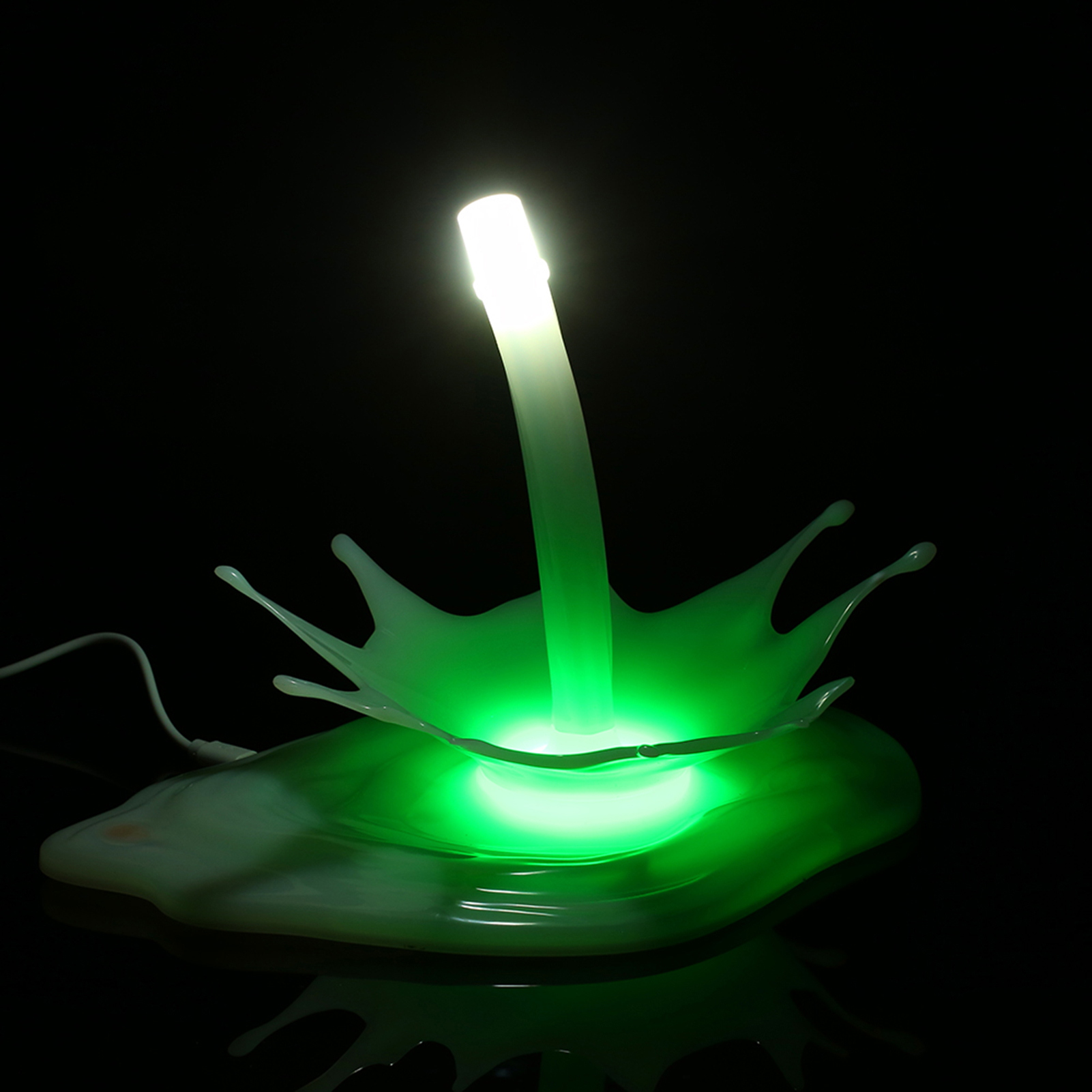 Grünes Licht geht von einer spritzförmigen Lampe aus. Ein vertikales Licht erhebt sich von der Basis.