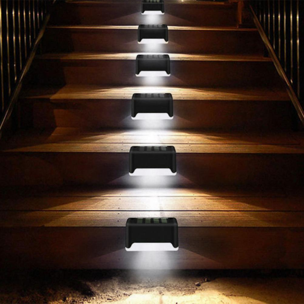 Holztreppe, beleuchtet von schwarzen Lichtern. Die Lichter sind rechteckig.