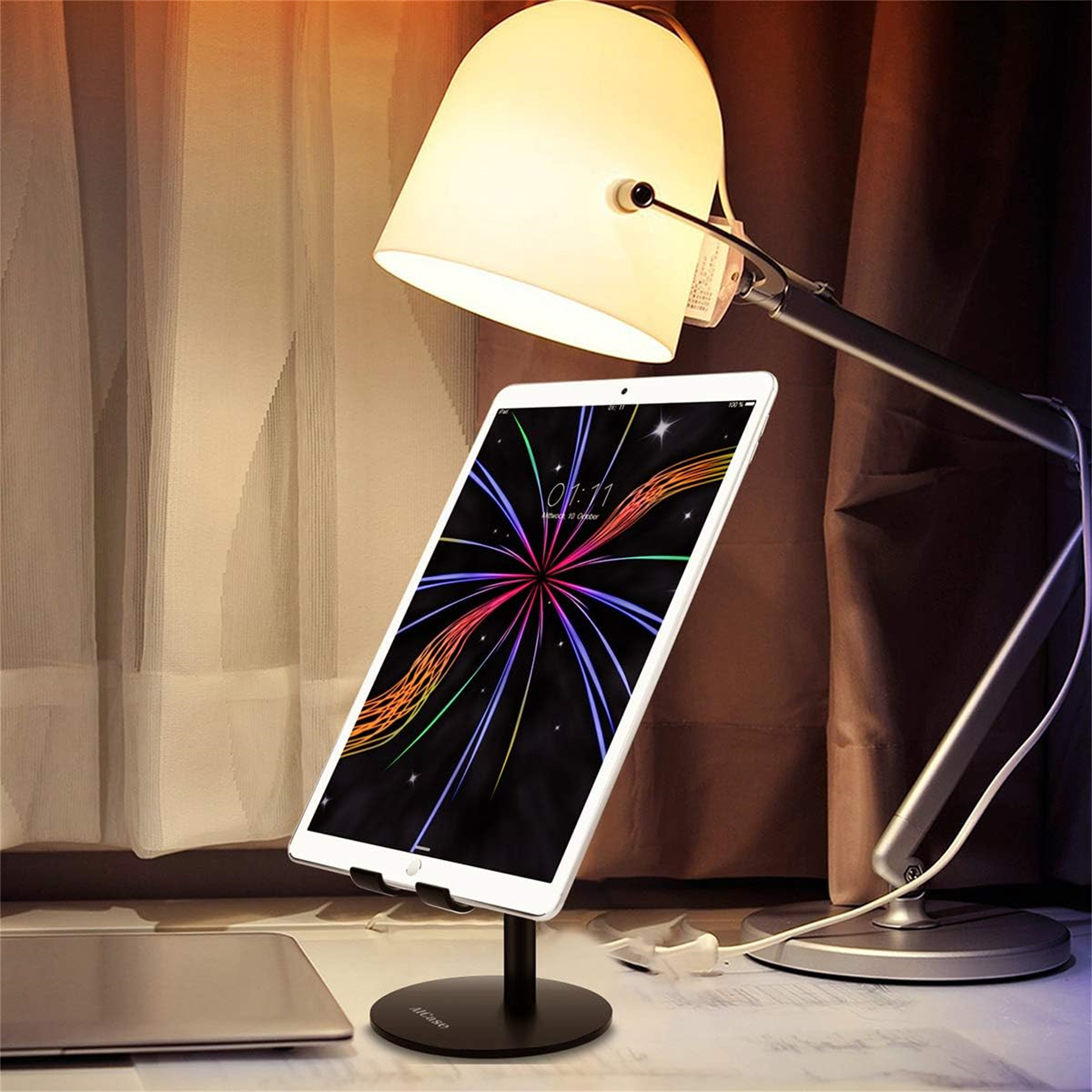 Ein Tablet auf einem Ständer unter einer Lampe. Das Tablet zeigt ein farbenfrohes Muster.