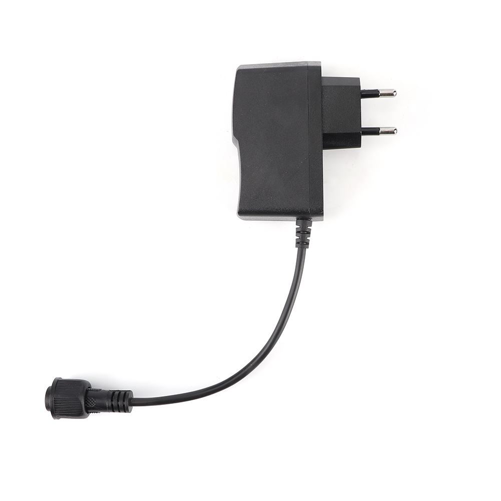 Ein schwarzes Netzteil mit Kabel und Stecker auf weißem Hintergrund, Draufsicht.