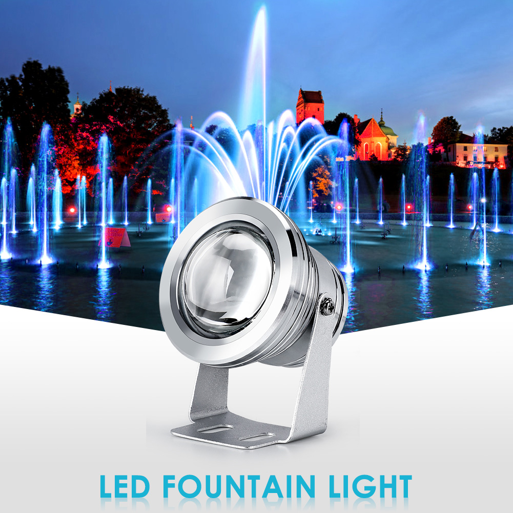 Ein Unterwasserlicht neben einem Springbrunnen mit Wasserstrahlen und Stadtbild im Hintergrund.