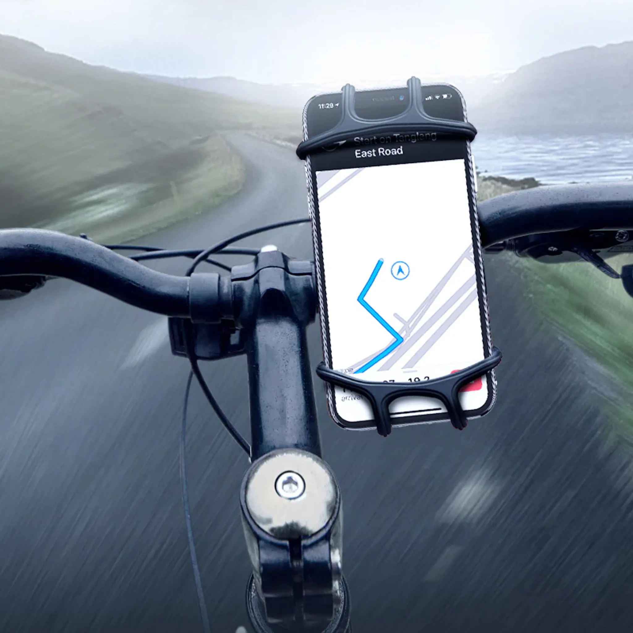 Ein Telefon, das an einem Fahrradlenker montiert ist, zeigt eine Karte mit einer Route. Der Hintergrund ist eine verschwommene Straße.