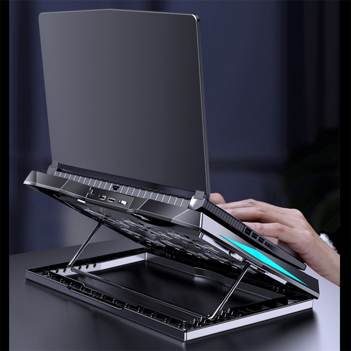 Laptop-Kühler mit blauen LED-Leuchten, mit einer Hand auf einem Laptop im Hintergrund.