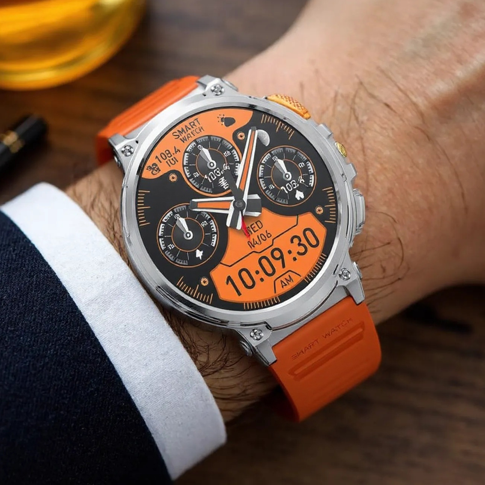 Eine Smartwatch am Handgelenk zeigt Zeit und Metriken an. Die Uhr hat ein orangefarbenes Armband und ein schwarzes Zifferblatt.