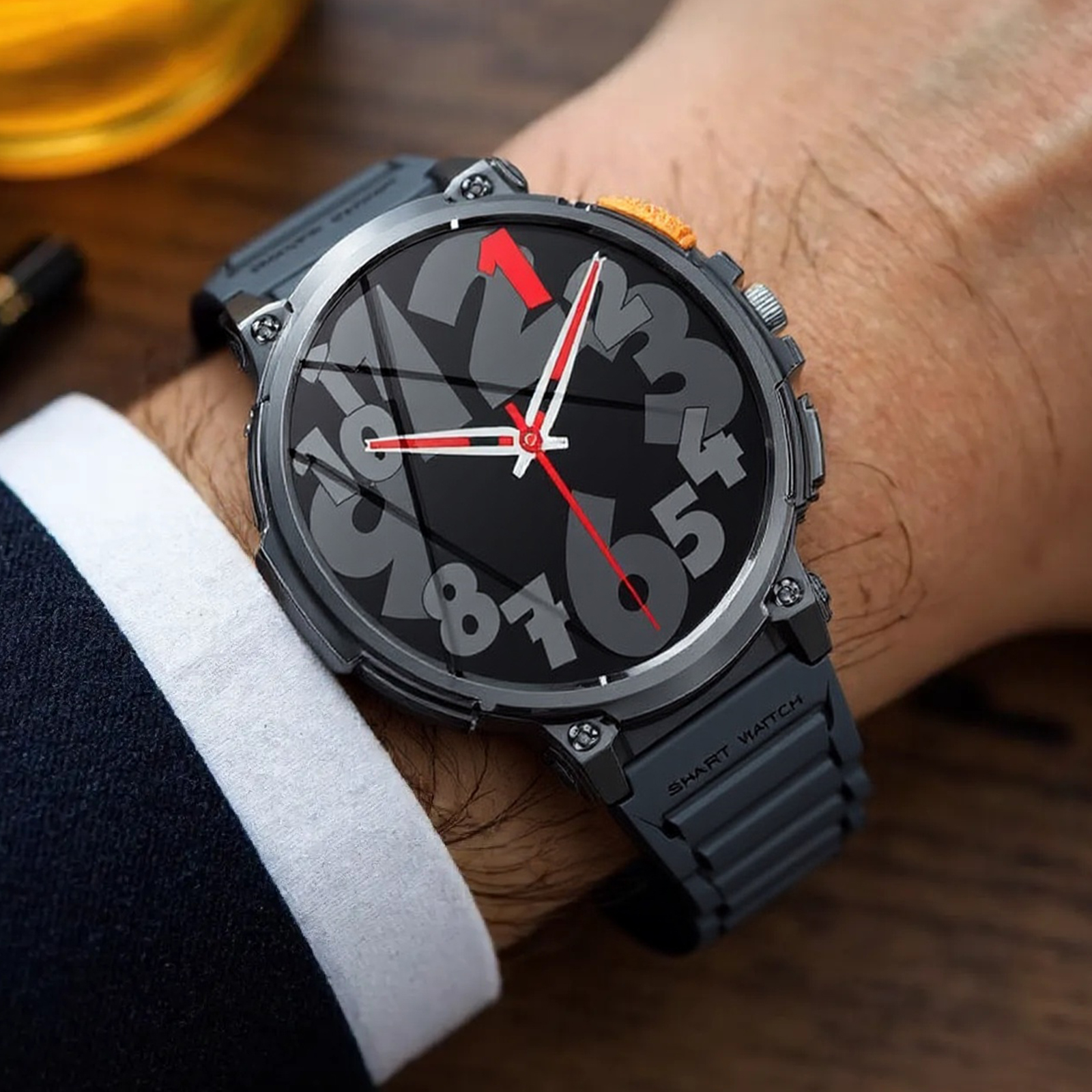 Das Handgelenk einer Person mit einer schwarzen Smartwatch. Das Zifferblatt zeigt große Zahlen und rote Zeiger.