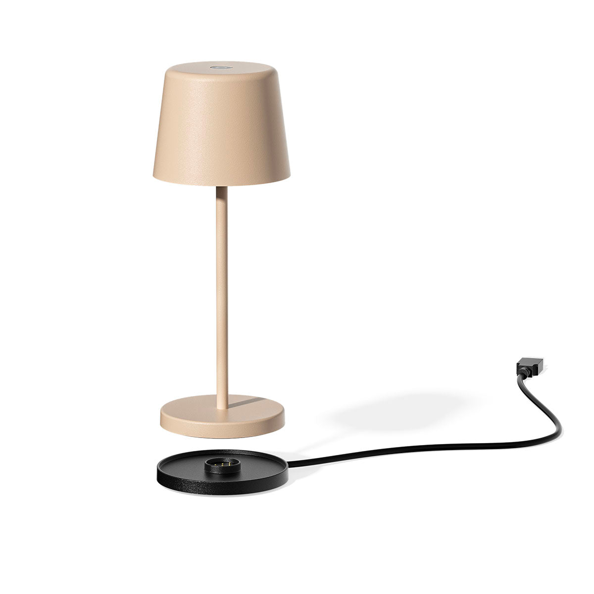 Eine beige Lampe auf einer schwarzen Ladestation, mit Netzkabel. Schatten auf weißem Grund.