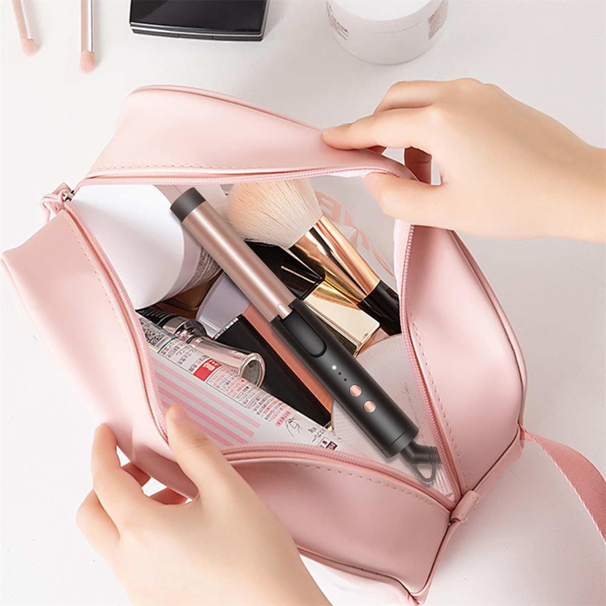 Eine rosa Make-up-Tasche ist geöffnet und mit Gegenständen gefüllt, darunter ein Lockenstab. Zwei Hände halten sie.
