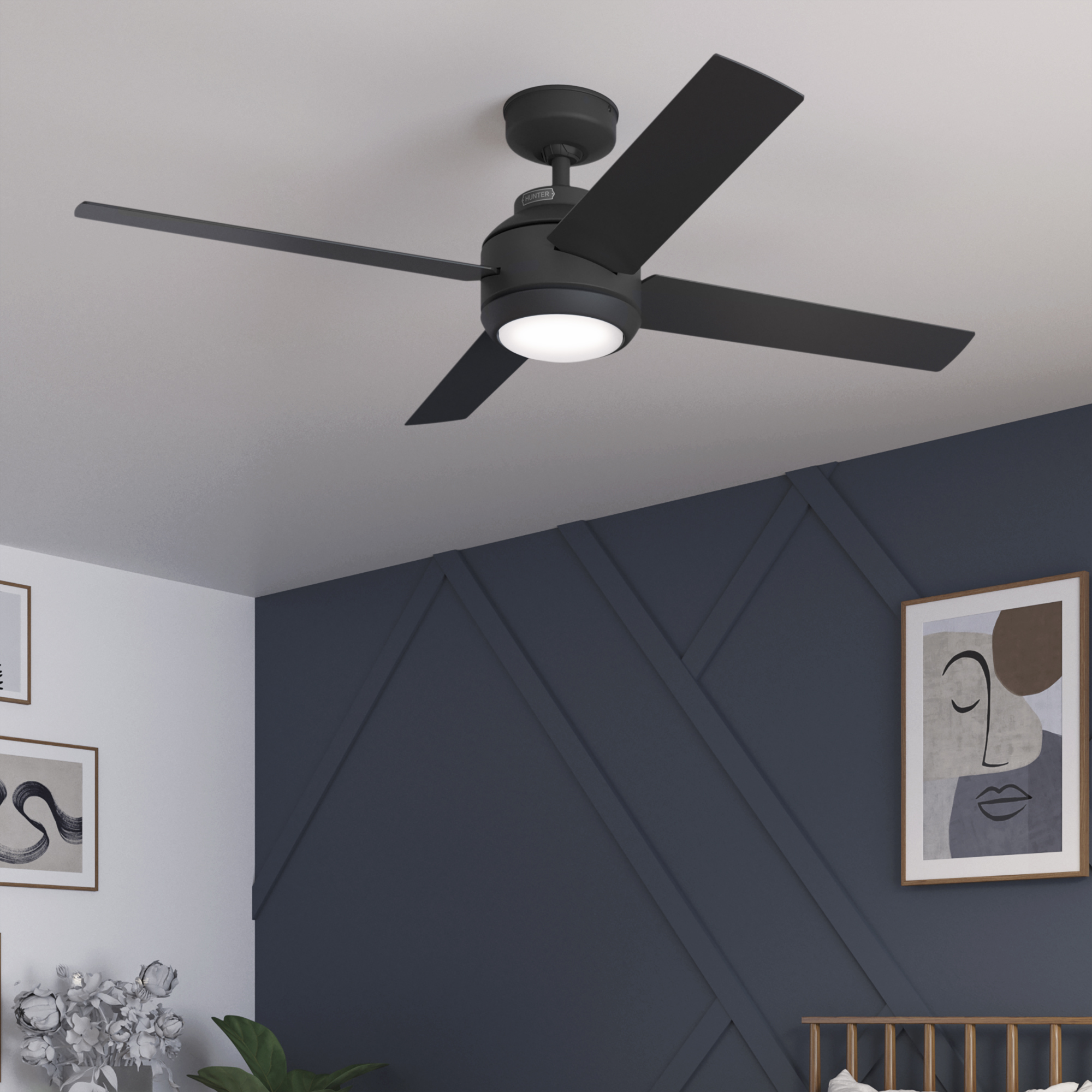 Schlafzimmer mit Deckenventilator, Bett und Kunst. Die Akzentwand ist dunkelblau mit geometrischem Design.
