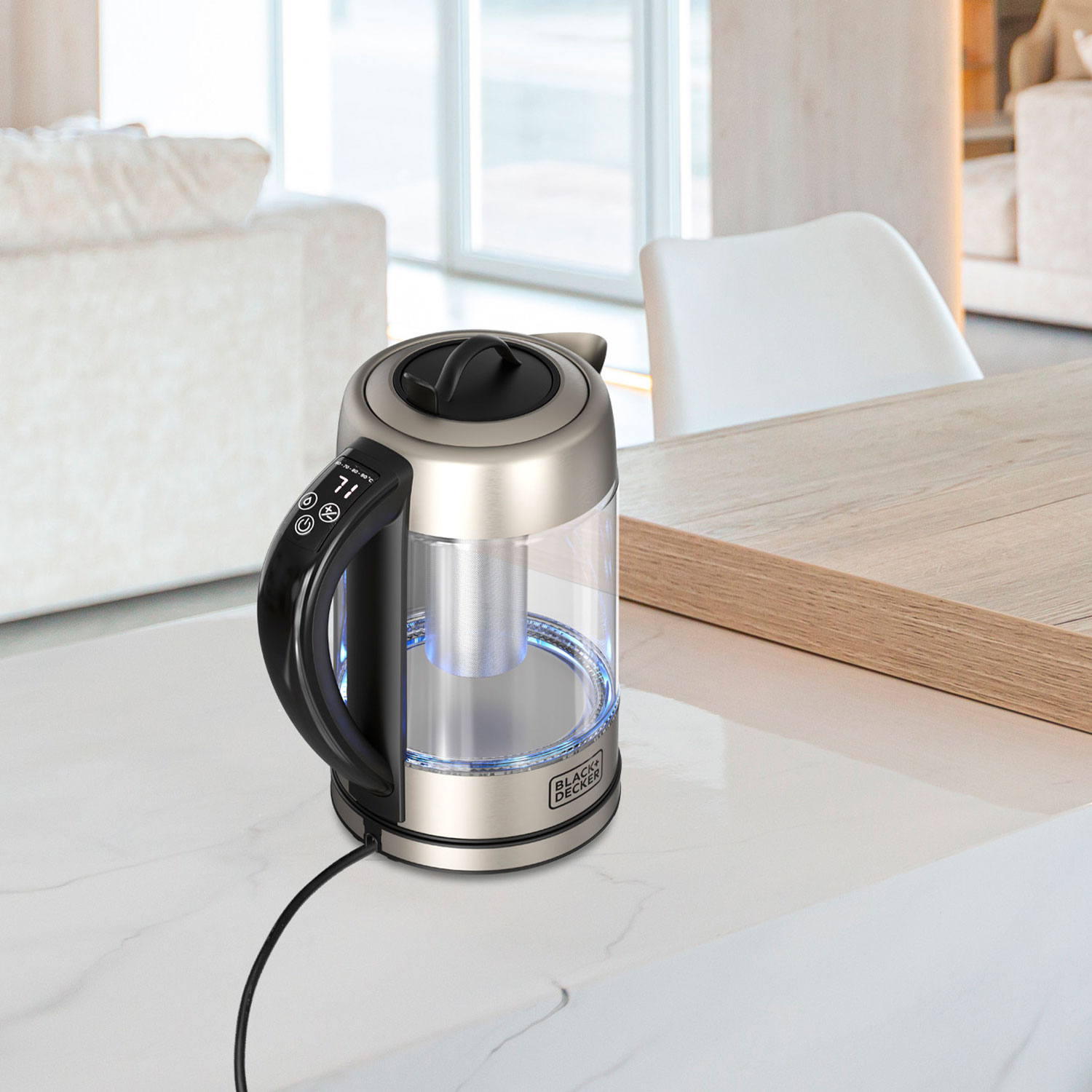 Szklany czajnik z czarną rączką i cyfrowym wyświetlaczem stoi na białym marmurowym blacie.