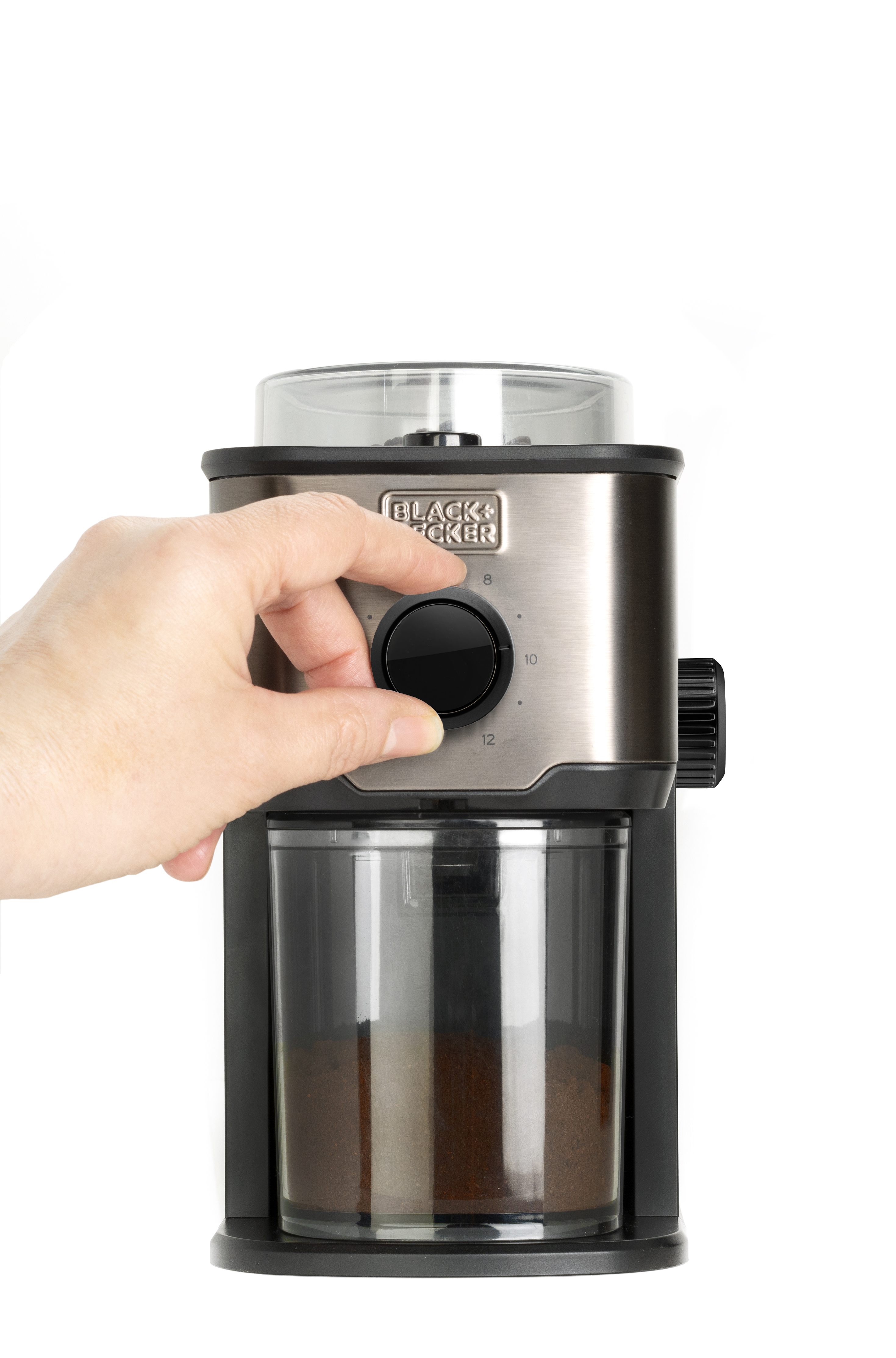 Młynek do kawy Black+Decker z ręką w pobliżu pokrętła wyboru grubości mielenia na białym tle.