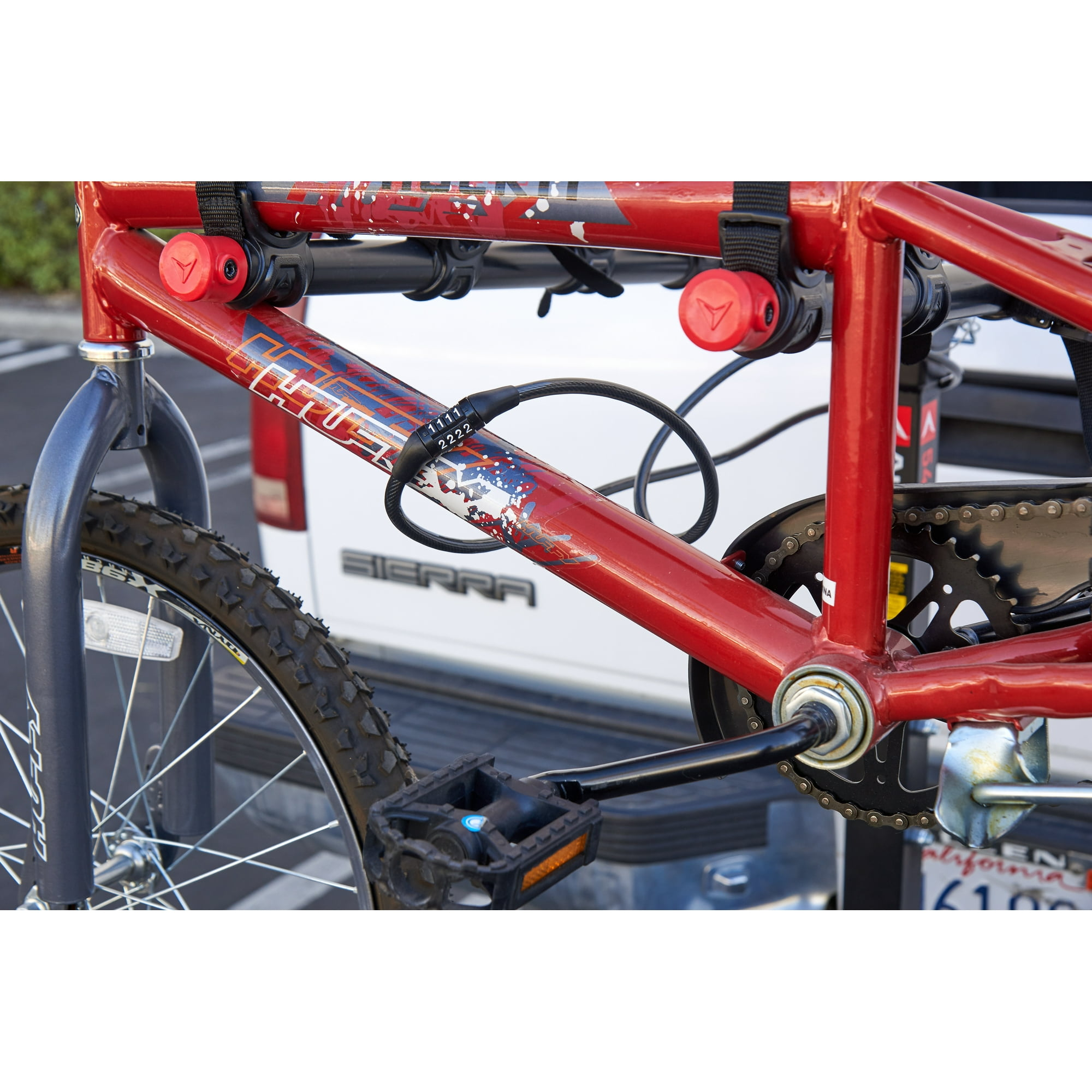 Ein rotes Fahrrad mit einem schwarzen Schloss, das um den Rahmen gewickelt ist, mit einem Zahlenschloss.