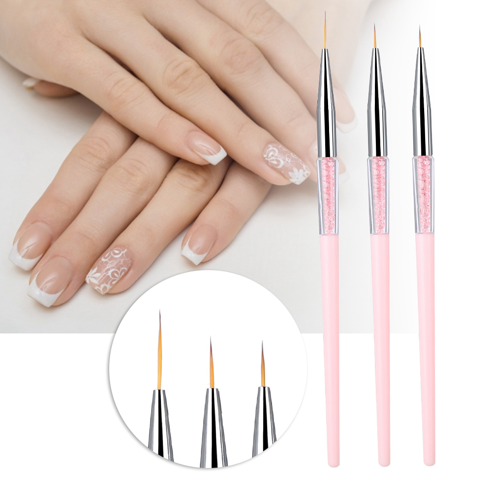 Nahaufnahme einer Hand mit manikürten Nägeln. Drei Nailart-Pinsel mit feinen Spitzen sind vor der Hand.