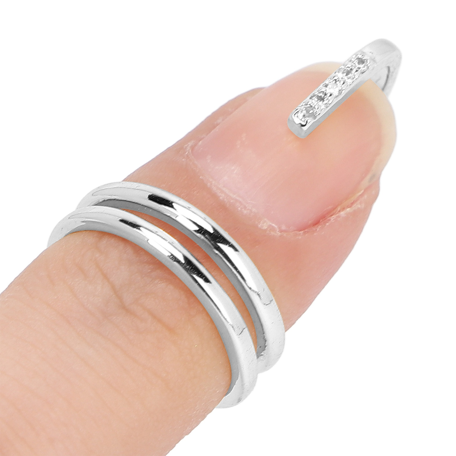 Ein silberner Ring mit Edelsteinen an einem Finger. Der Ring vor weißem Hintergrund.