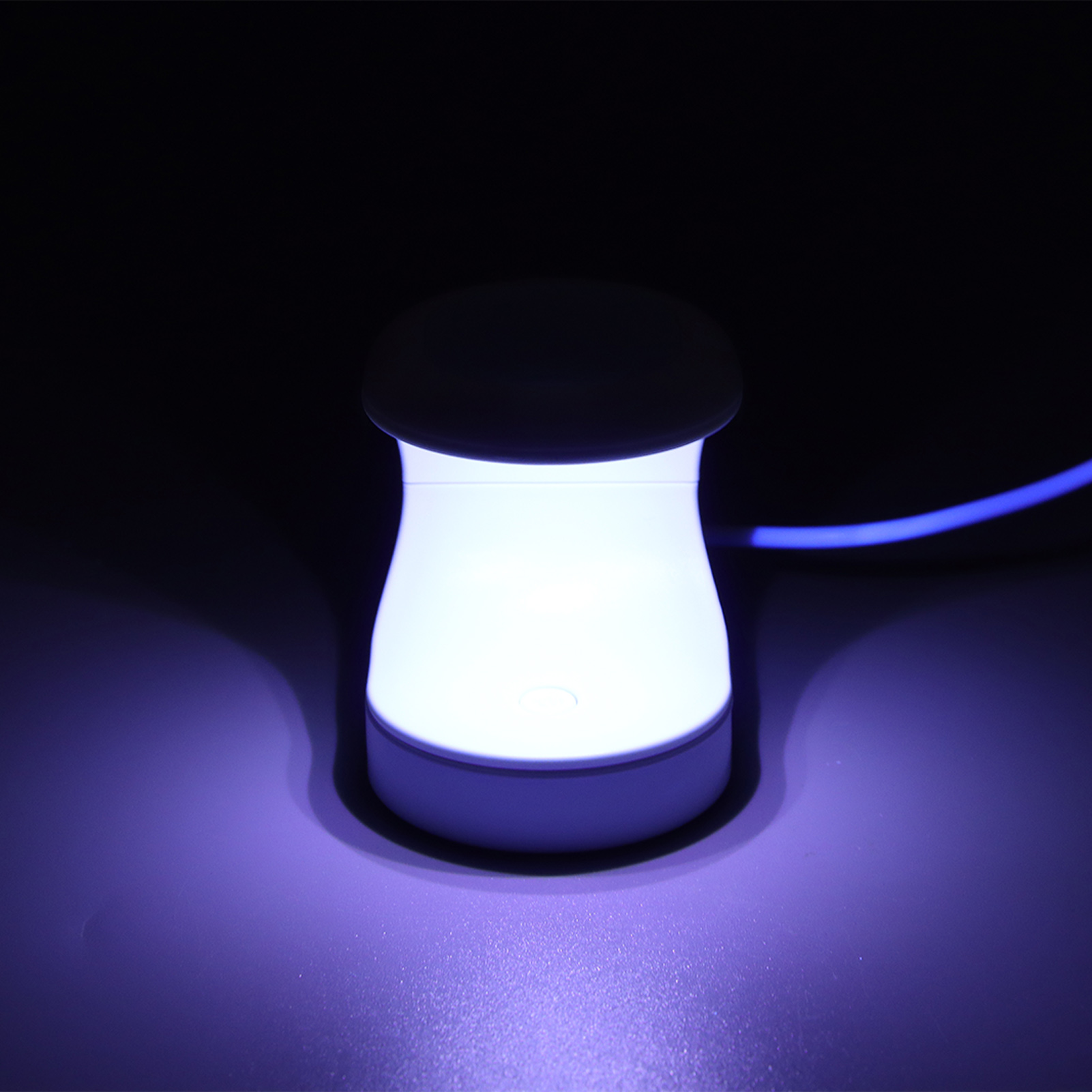 Weiße Lampe, die ein sanftes, violettes Leuchten vor dunklem Hintergrund ausstrahlt.