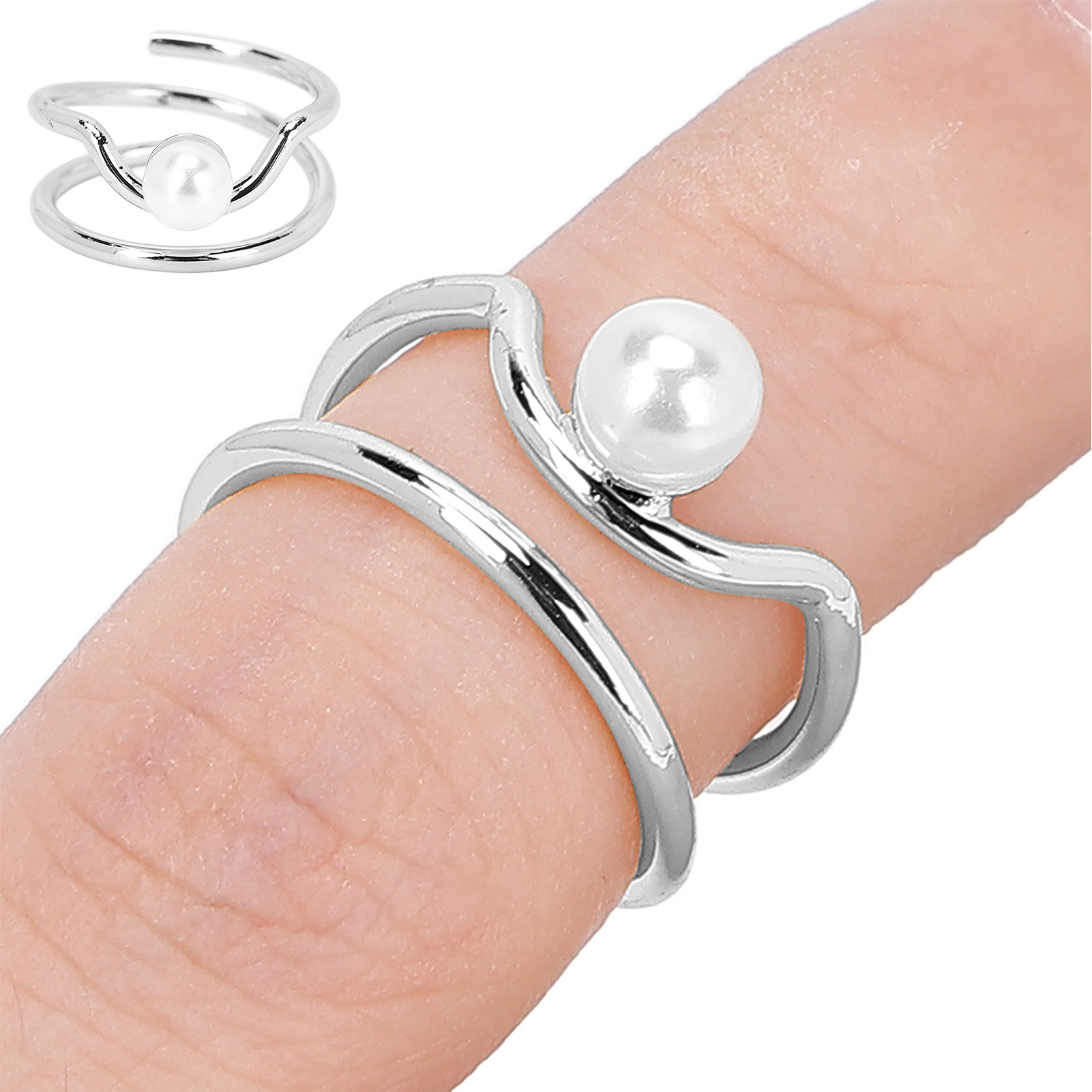 Ein silberner Ring mit einer Perle an einem Finger. Ein weiterer Ring ist im Hintergrund.