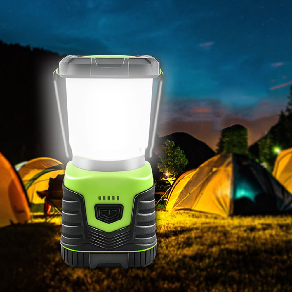 Grüne und schwarze Campinglaterne, die nachts leuchtet. Der Hintergrund ist eine Campingszene.