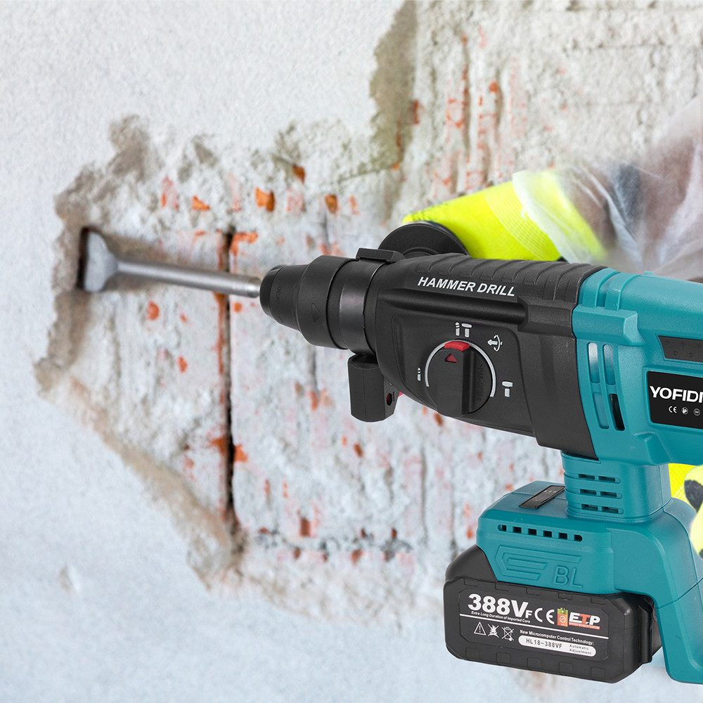 Ein Bohrhammer bohrt in eine Wand. Die Wand weist Schäden auf. Eine behandschuhte Hand bedient den Bohrer.